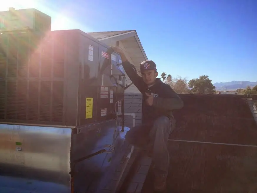 HVAC technician performing Air Duct Cleaning on a rooftop unit in New Albany
